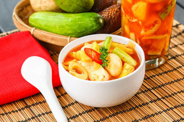 Asinan buah segar dengan kombinasi mangga, nanas, dan kedondong, disajikan dengan taburan kacang tanah goreng dan biji wijen, menggugah selera di hari yang panas